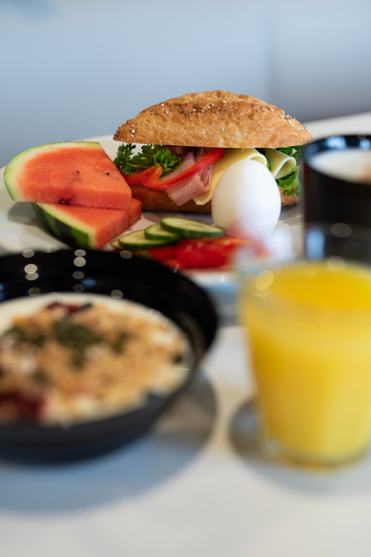 Frukostmacka med ägg, skinka och ost serverad med melon och apelsinjuice