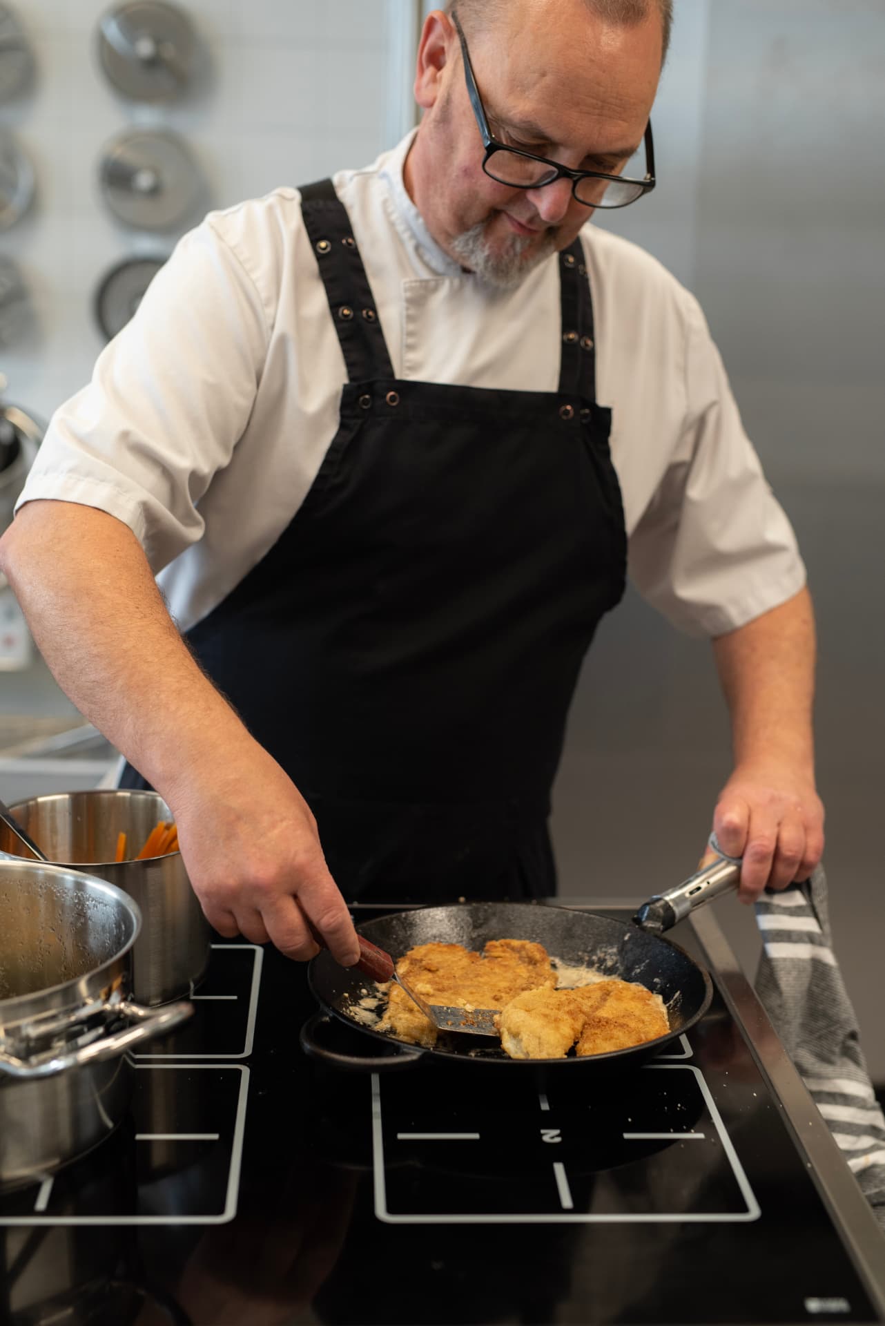Kock lagar varmrätt i panna på Restaurang Via