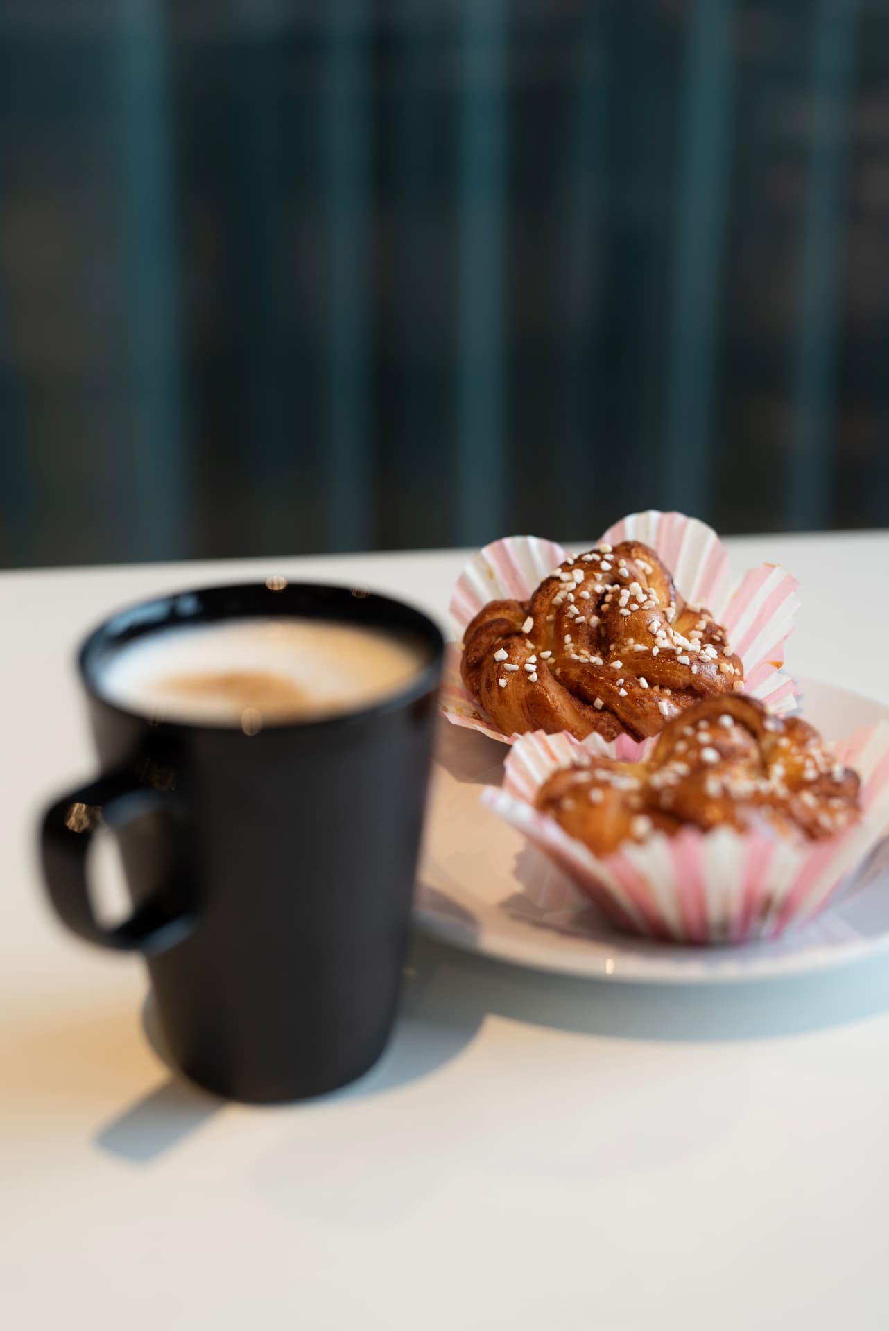 Hembakta kanelbullar med pärlsocker och en kopp kaffe